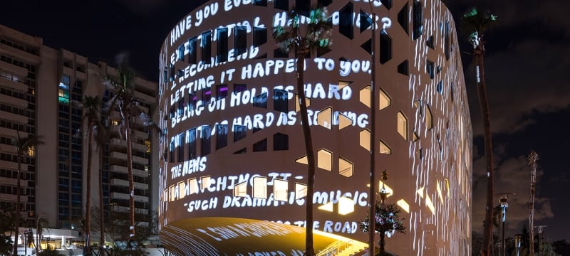 words projected on the exterior of faena forum