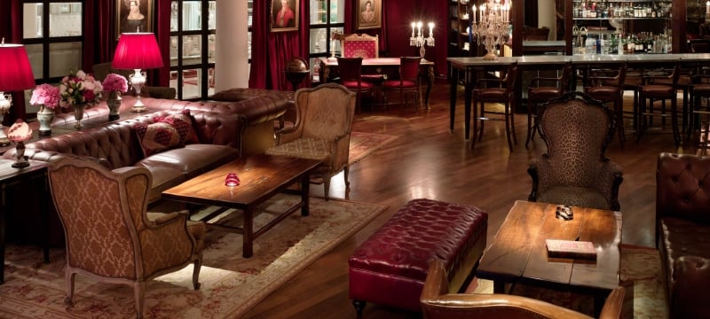 red ottoman and lamps amongst tables and chairs in lounge