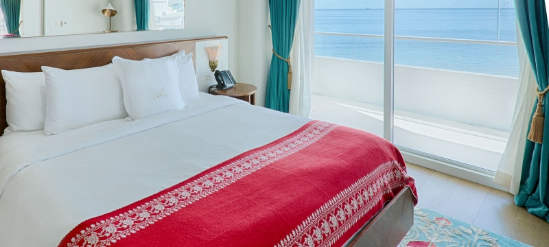 bedroom with patio door with ocean in background