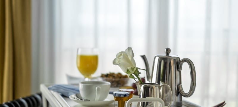 breakfast on a tray in front of curtained window
