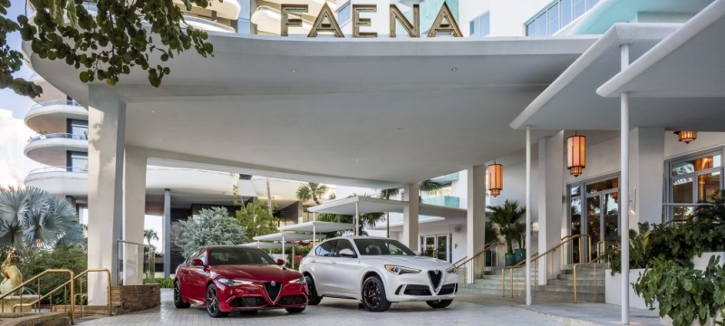 Red and white alfa romeo cars parked in front of Faena hotel