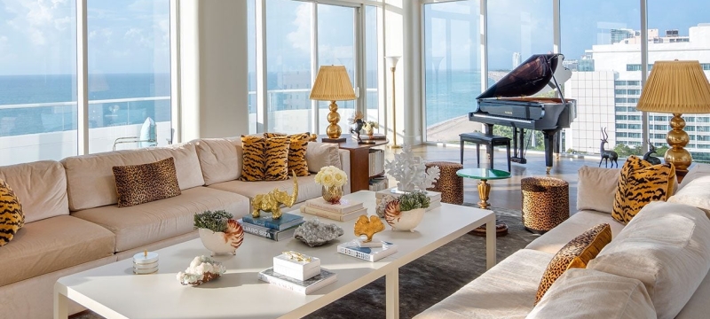 large hotel penthouse with living space and grand piano in the distance