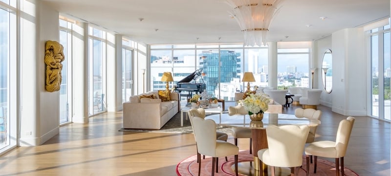 large hotel penthouse with living space and grand piano in the distance