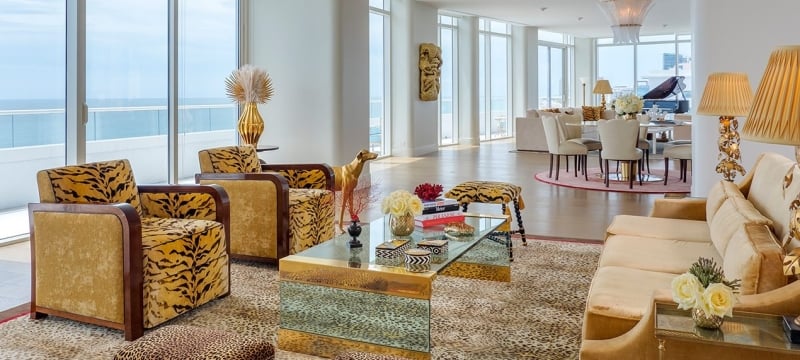 large hotel penthouse with living space and grand piano in the distance