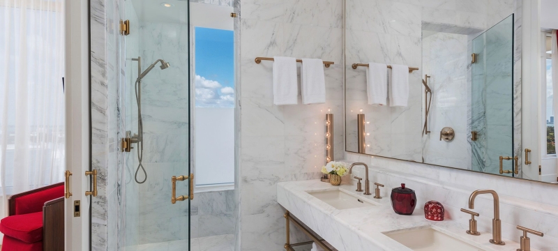 hotel bathroom with two sinks and shower