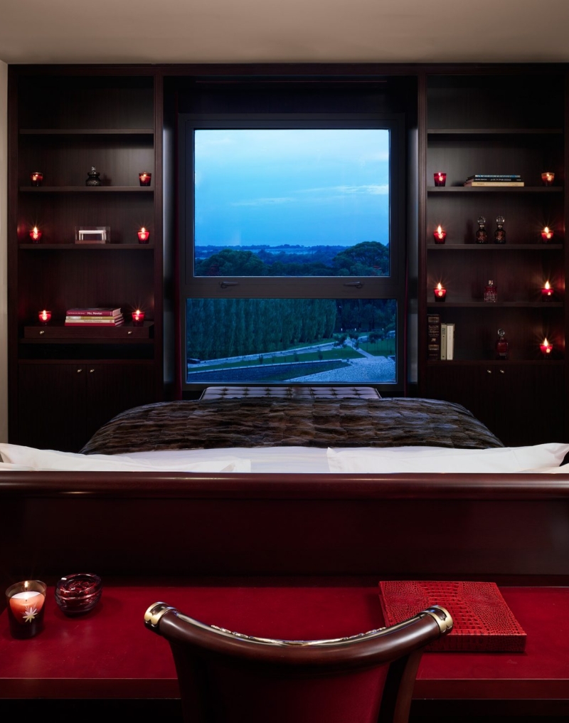 suite hotel bed facing windows with bookshelves