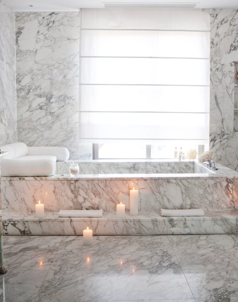 bathtub in hotel room lit by candles