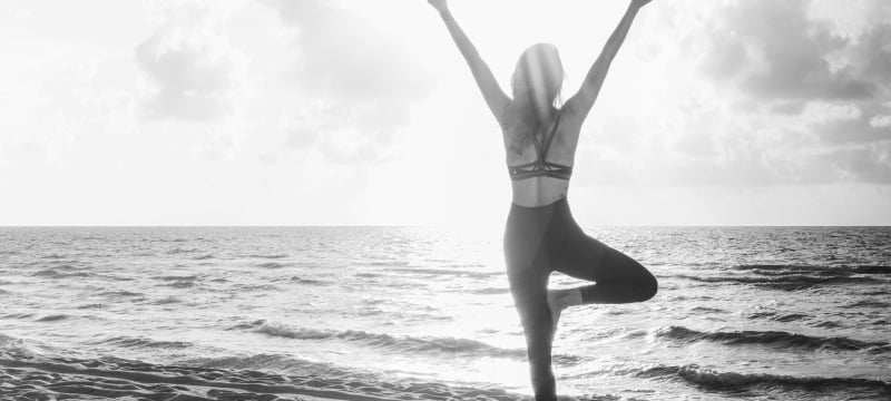 woman on beach holding a yoga pose